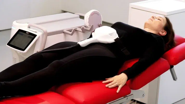 Patient lying on a treatment bed with a TightWave applicator strapped over the abdomen