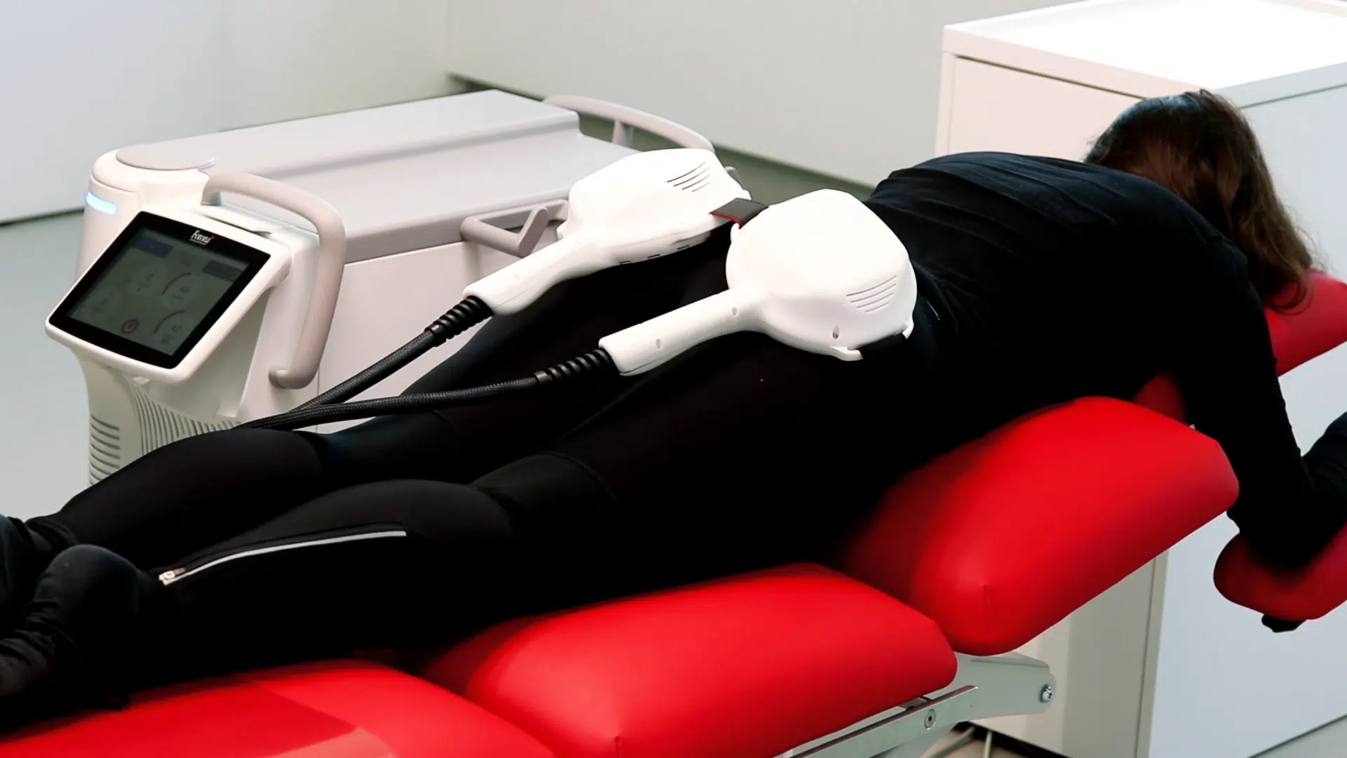 Patient lying face down with TightWave applicators on the glutes