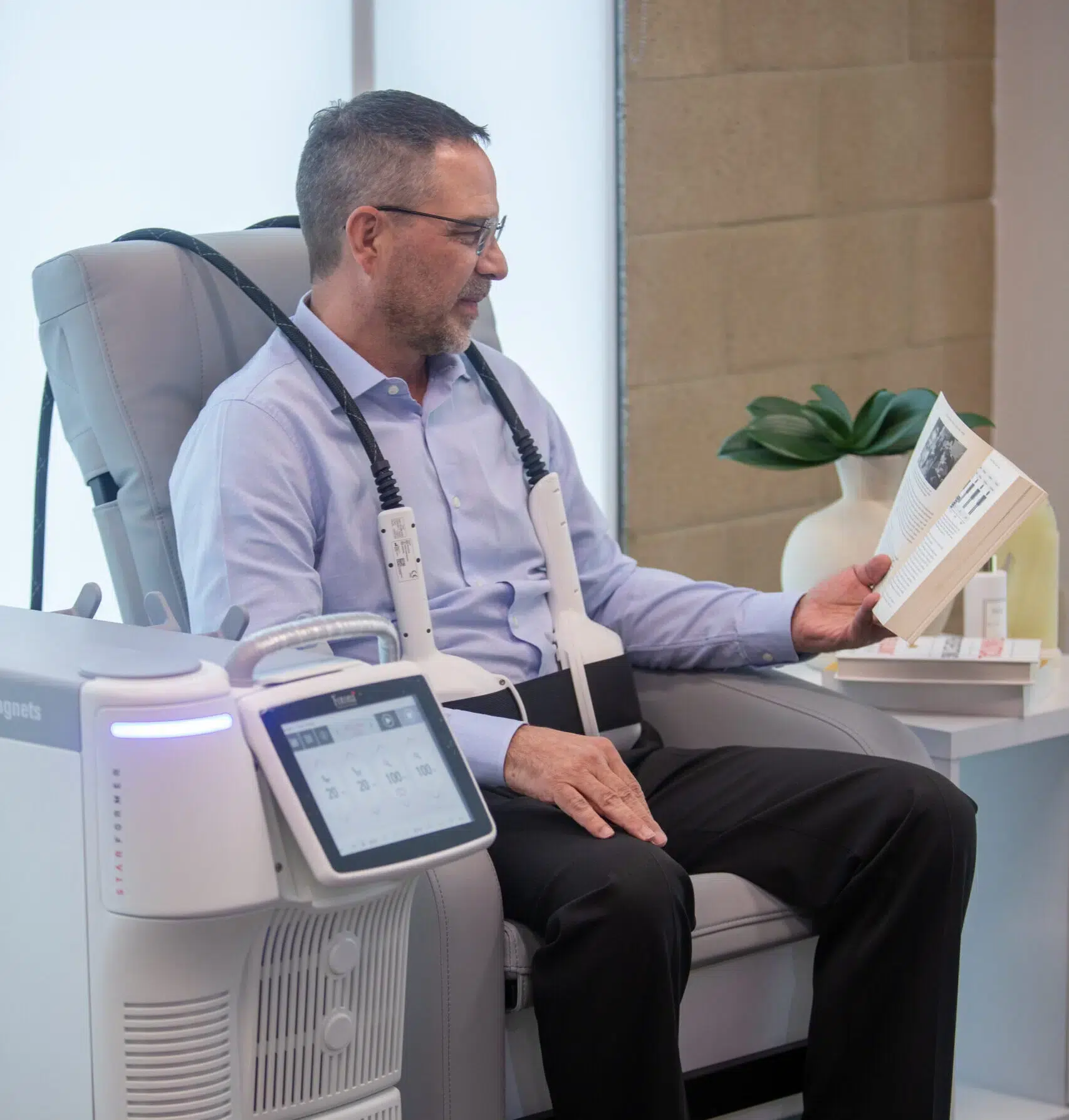 Patient seated fully clothed in the Fotona StarFormer chair during a CoreRestore session
